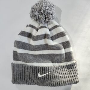 Nike Swoosh Grey and White striped Youth beanie featuring a pom-pom on top